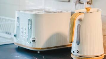 A kitchen with a toaster and a kettle on a countertop.