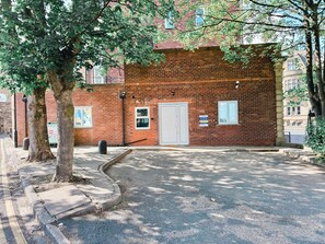 A brick building with a white door, a small window, and a sign on the wall.