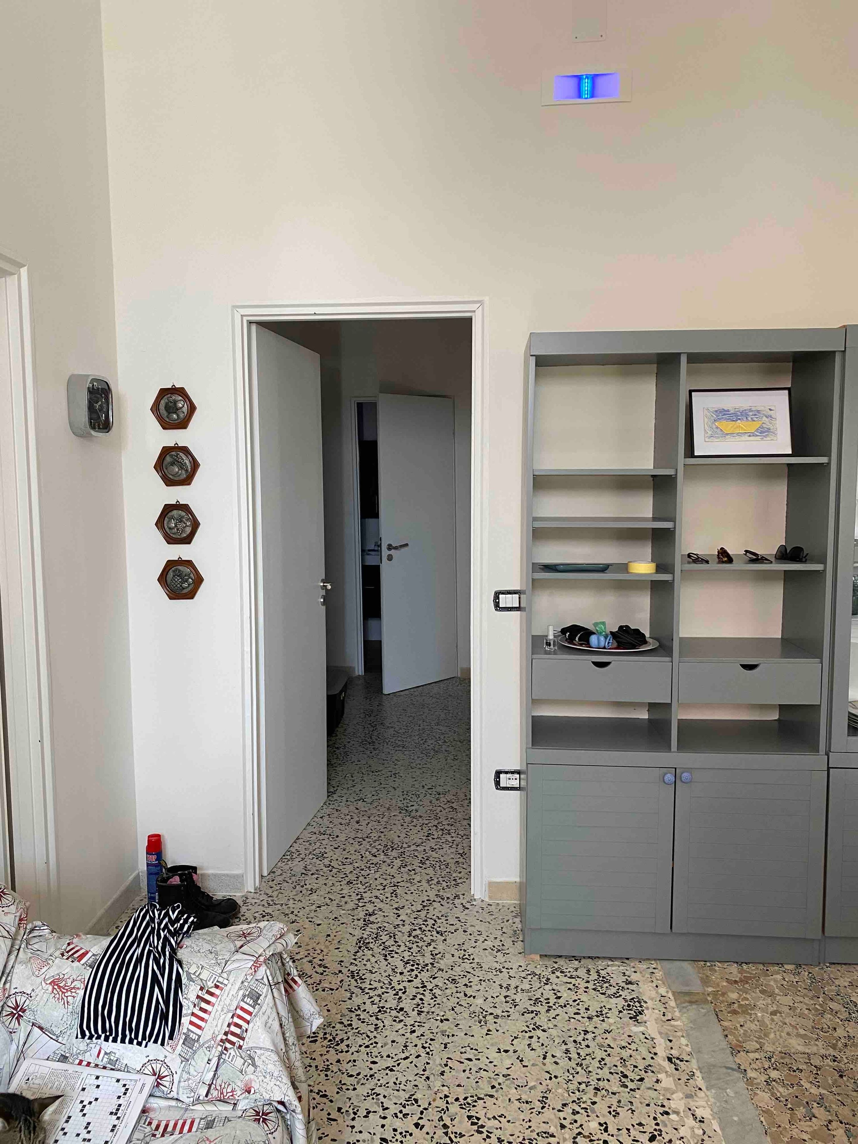 Una stanza con un letto, un armadio e una porta che dà su un'altra stanza.
