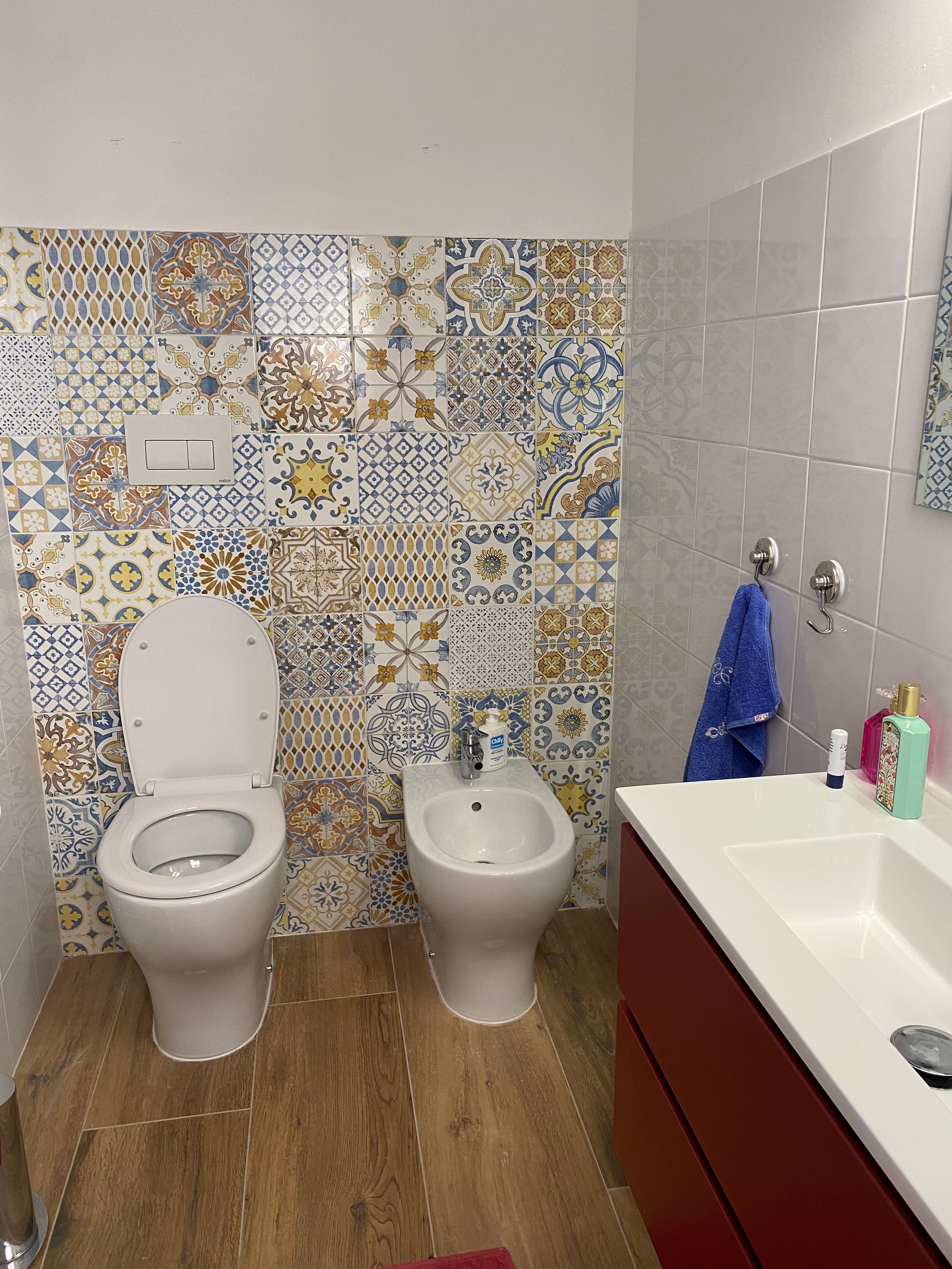 A bathroom with a toilet, bidet, and a sink with a mirror.