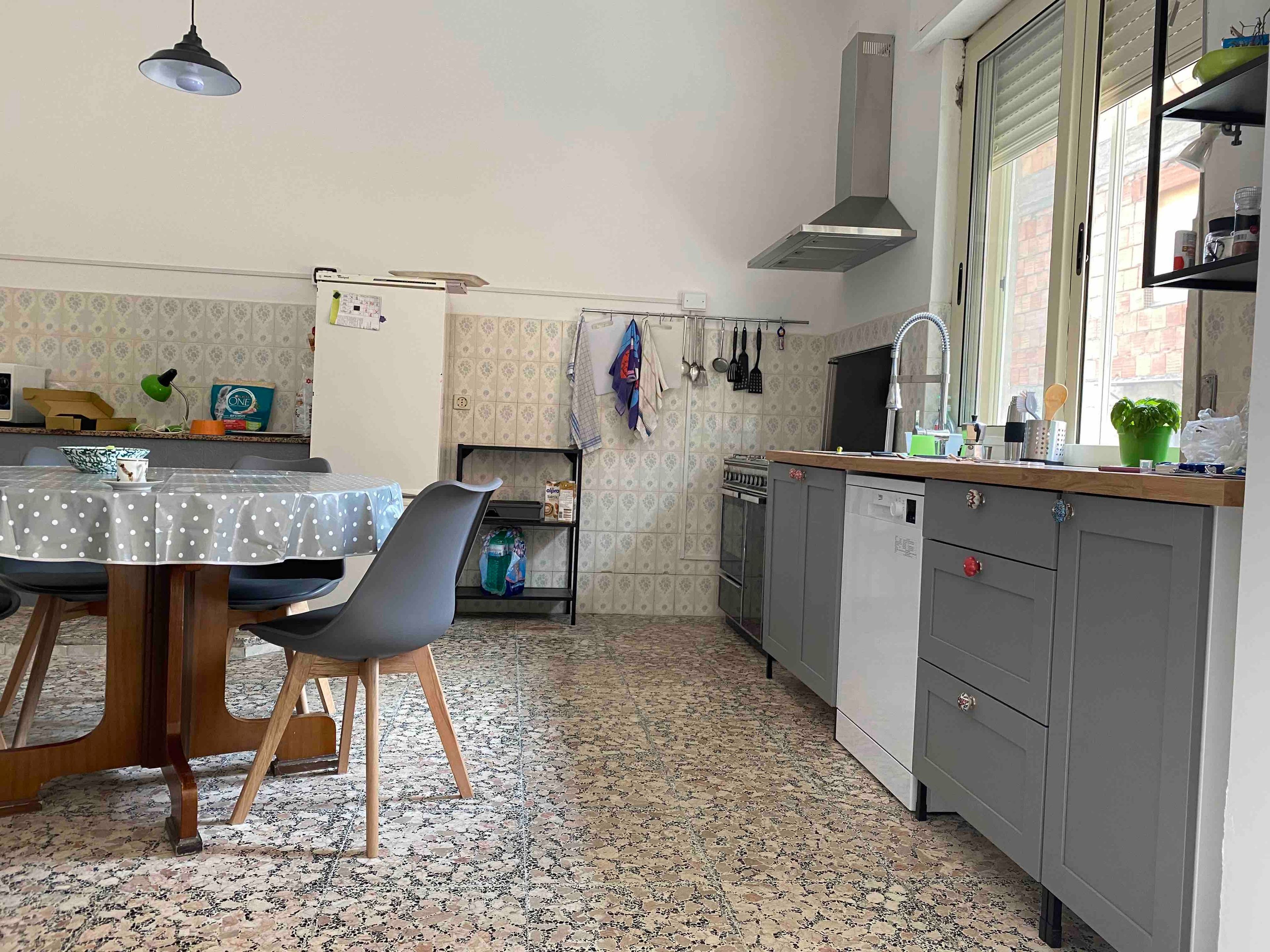 A kitchen with a dining table, chairs, a stove, and a sink.