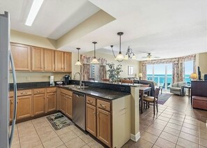 A kitchen with wooden cabinets, a central island, and pendant lighting. - Malibu Pointe 1001 -I/O Pools-Lazy River-4BR/4BA (North Myrtle Beach)