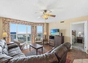 A living room with a sofa, armchair, coffee table, and a television. - Malibu Pointe 1001 -I/O Pools-Lazy River-4BR/4BA (North Myrtle Beach)