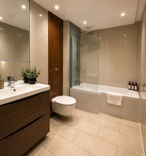 Un baño moderno con un espejo grande, un lavabo blanco, un inodoro, una ducha con mampara de vidrio y una bañera.