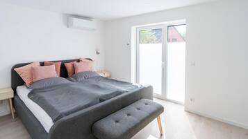 A modern bedroom with a bed, bedside tables, and a bench.