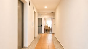 A corridor with a tiled floor leading to a dining area with a table and chairs. - Ocean View and Comfort for Your Stay (Bolívar)