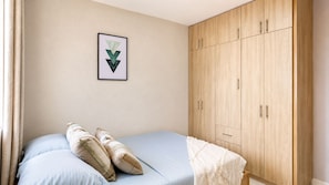 A bedroom with a bed, pillows, a wardrobe, and a framed picture on the wall. - Ocean View and Comfort for Your Stay (Bolívar)