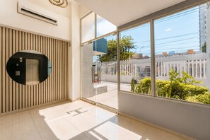 A modern interior with a large window, a wall-mounted elevator, and a tiled floor. - Ocean View and Comfort for Your Stay (Bolívar)