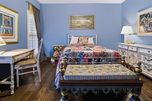 A bedroom with a bed, a dresser, a chair, a table, and a window with curtains. - Luna Vista With Private Pool Oasis (Kerrville)