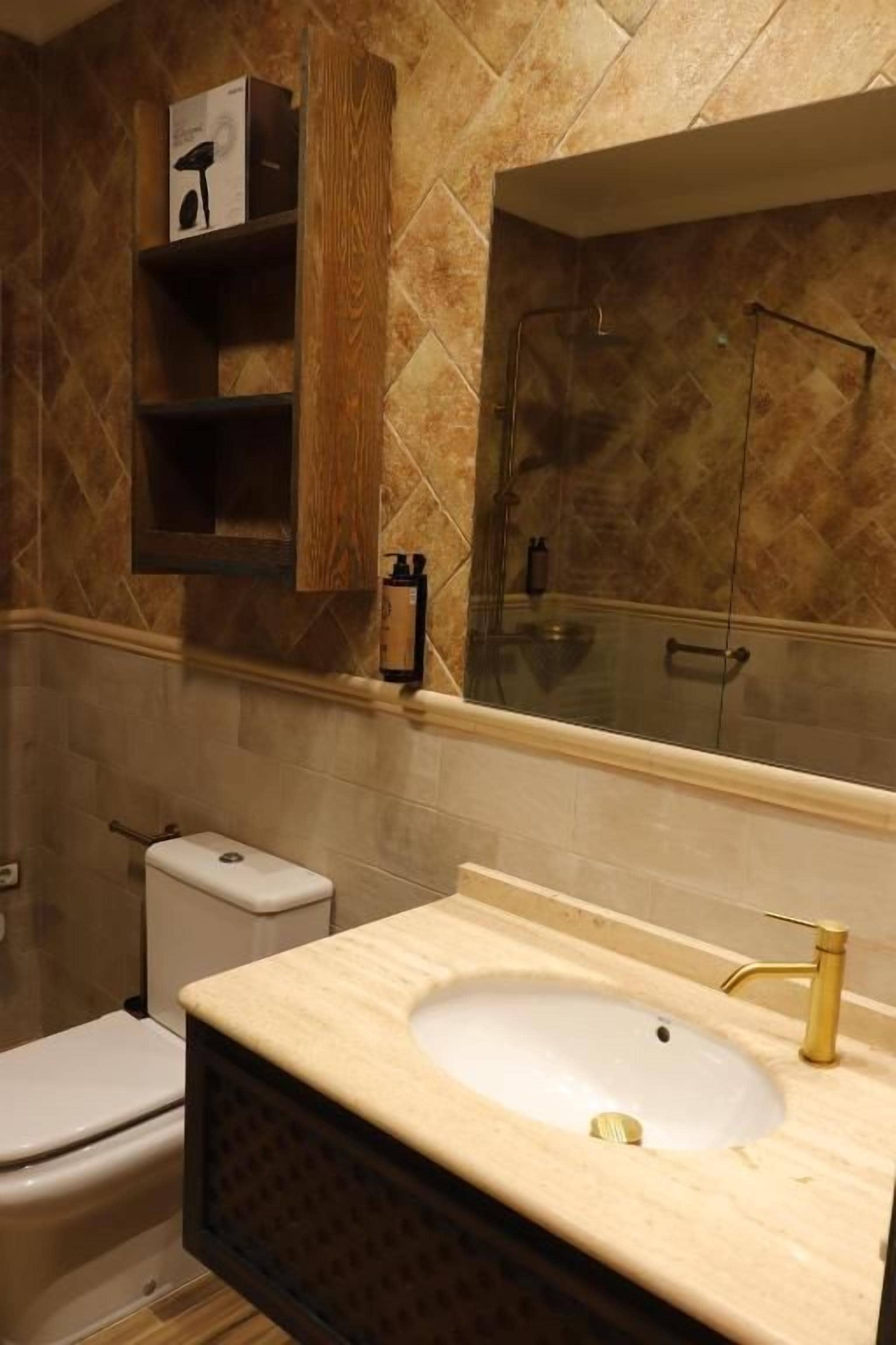 Un baño con inodoro, lavamanos y espejo.