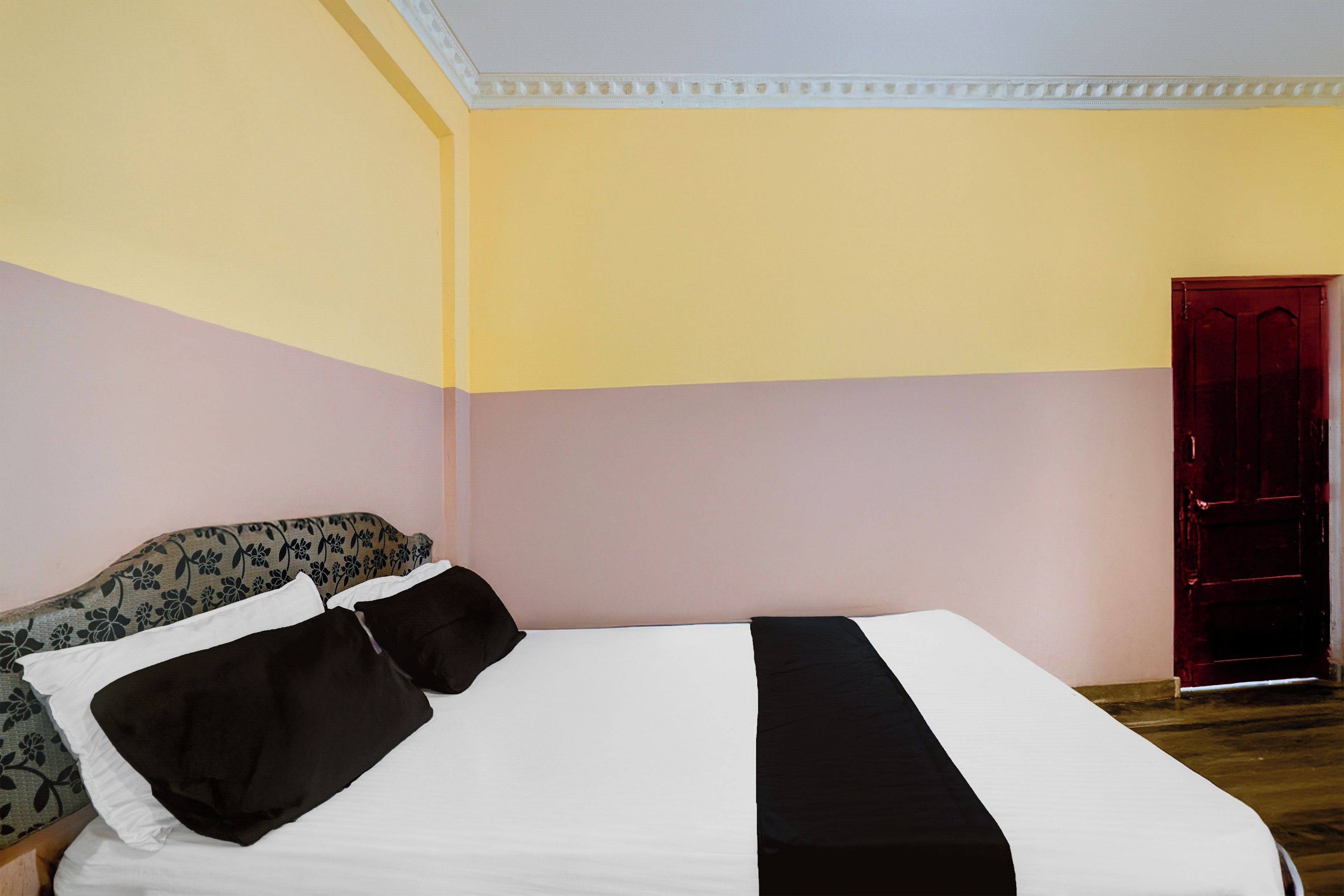 Een kamer met een bed, een deur en een kussen met dessin.
