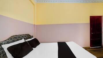 Een kamer met een bed, een deur en een kussen met dessin.