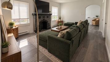 A modern living room with a sectional sofa, a fireplace, and a flat-screen TV.