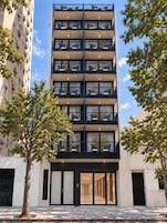 A multi-story hotel with balconies, a ground entrance, and a number '336' on the door.