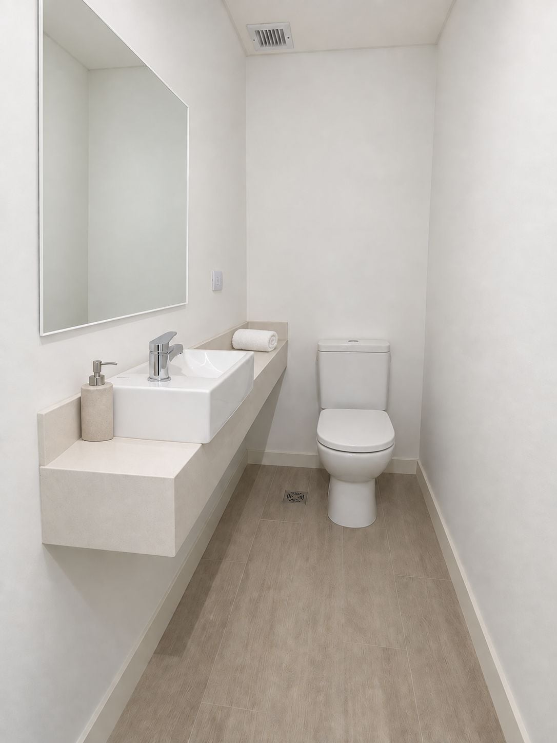 A modern bathroom with a white sink, mirror, and toilet.