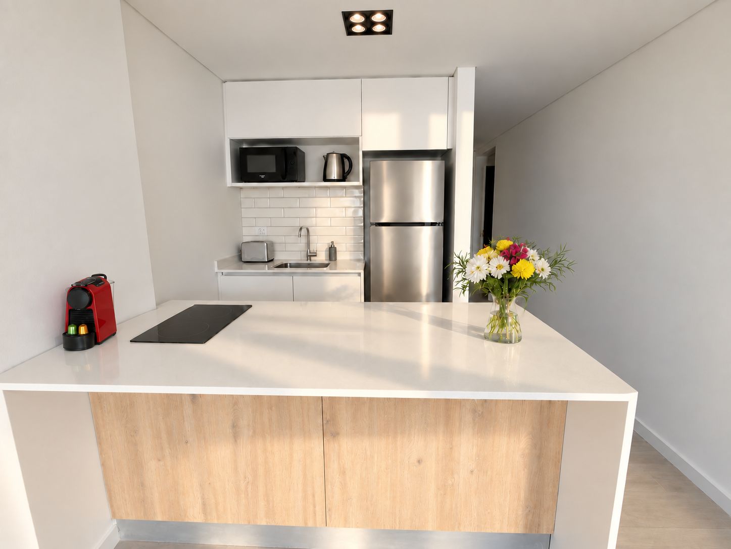 Una cocina moderna con una isla central, electrodomésticos de acero inoxidable y un diseño minimalista.