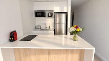 Una cocina moderna con una isla central, electrodomésticos de acero inoxidable y un diseño minimalista.