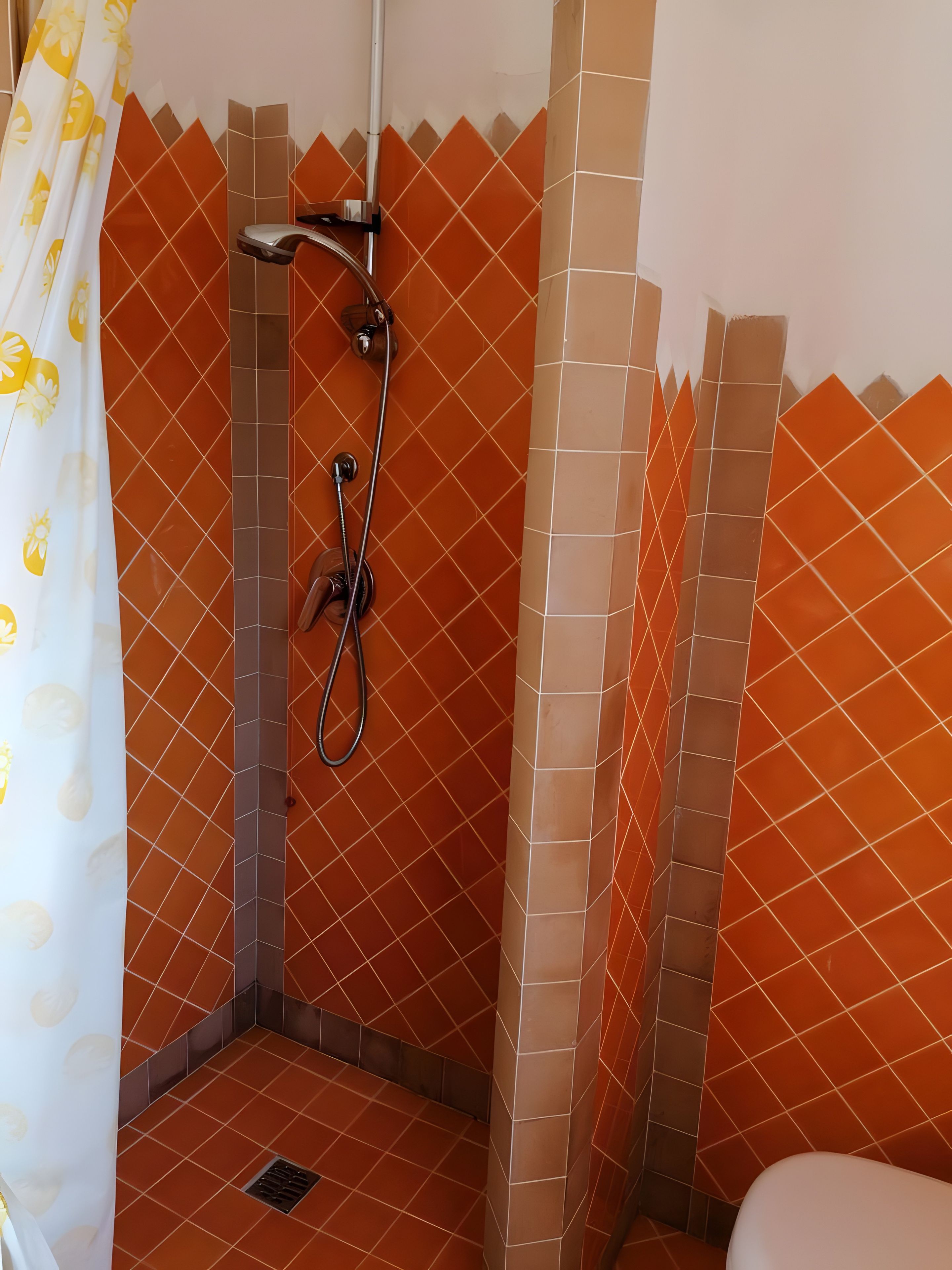 A shower area with a showerhead and a handheld shower attachment.