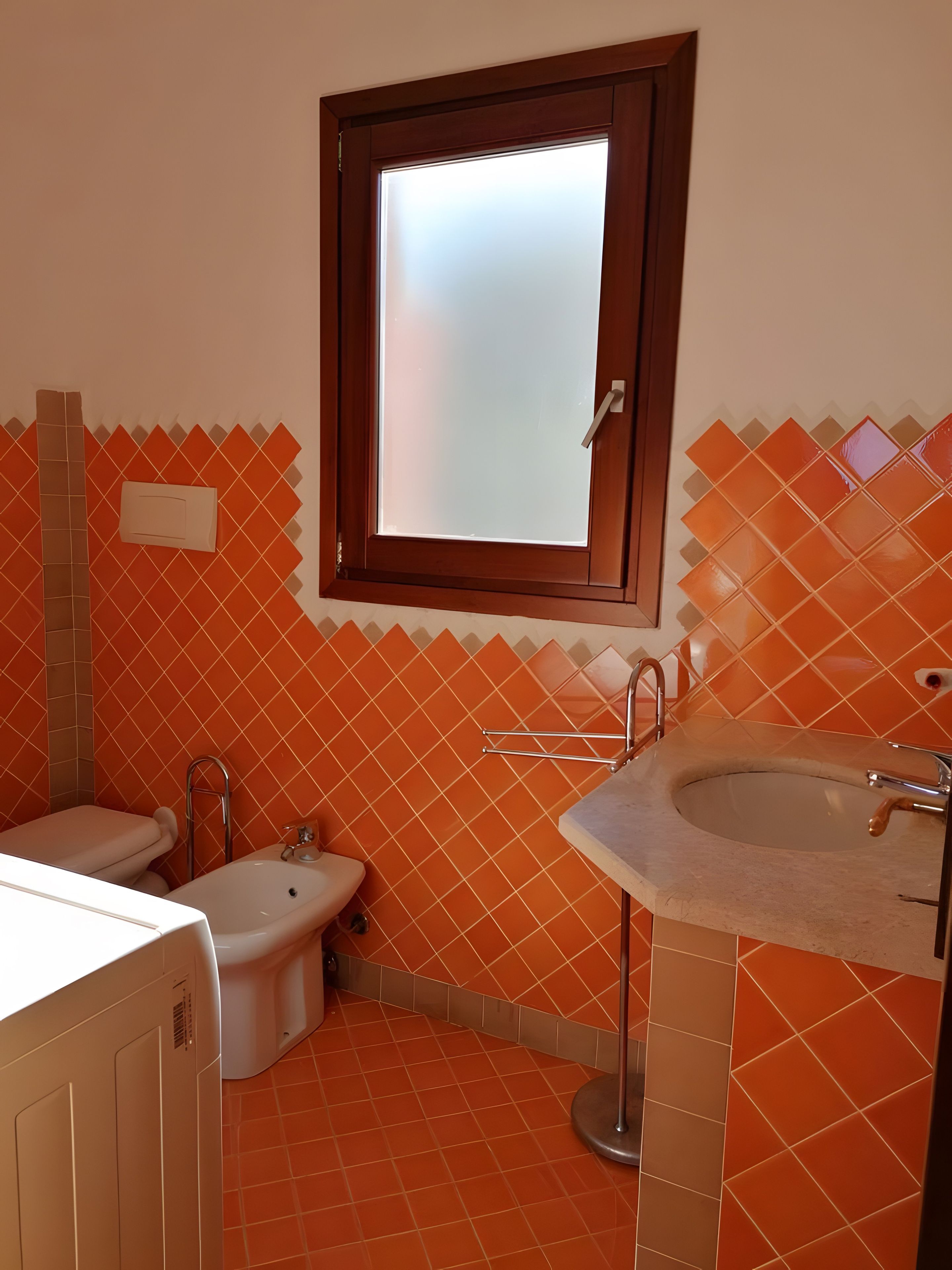 Un bagno con il water, bidet e lavabo.
