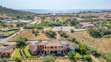 A coastal residential area with terraced houses, a swimming pool, and a view of the sea.