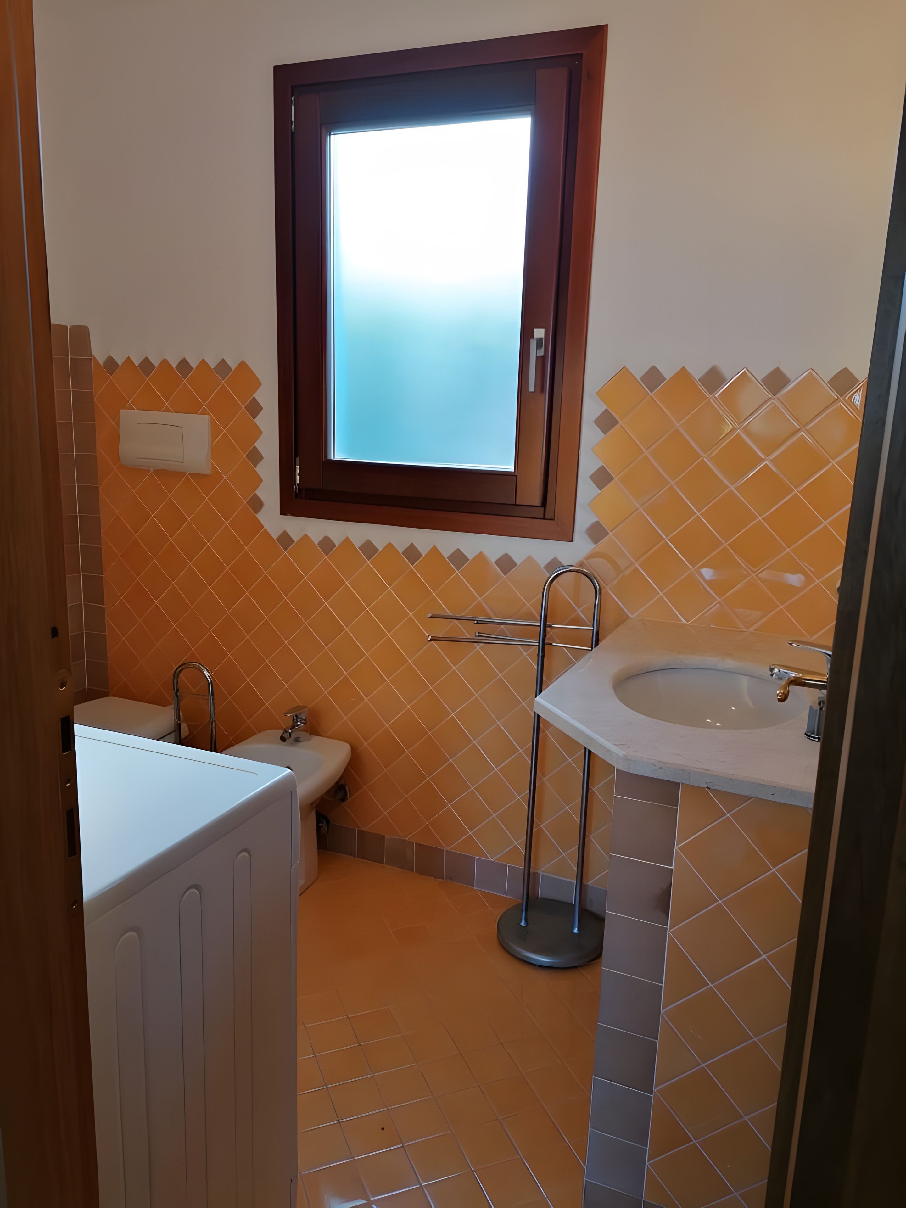 Un bagno con vasca, WC e lavandino.
