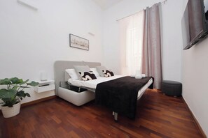 Ein modernes Schlafzimmer mit einem Bett, einem Nachttisch und einer Topfpflanze.