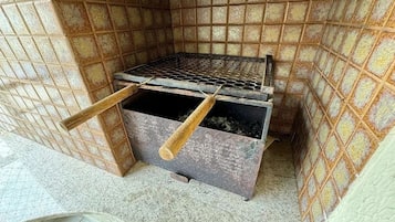 A compact kitchen with a metal stove, wooden utensils, and a tiled backsplash.