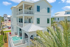 A multi-story white building with a balcony, a pool, and a view of the surrounding area. - Amberjack | 7BR | Heated Pool & Spa | Sleeps 16 (Inlet Beach)