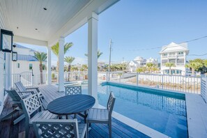 A covered outdoor area with a pool, seating, and a view of neighboring buildings. - Blue Fin | Heated Pool | Sleeps 26 | Near Rosemary Beach (Inlet Beach)