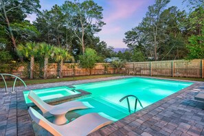 A rectangular swimming pool with a built-in slide, surrounded by a wooden fence, and a brick patio. - 🏖️Front Porch Sitting | Private Pool, Spa & Screened Porch | Near Beach (Rosemary Beach)