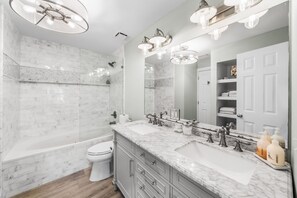 A modern bathroom with a bathtub, toilet, and vanity with a large mirror. - 🚲Lakeside Villa | Private Dock, Kayaks & Bikes | Minutes to 30A Beaches🏖️ (Seacrest)