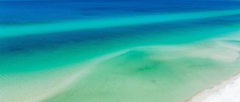 A beach with clear turquoise water and white sand.