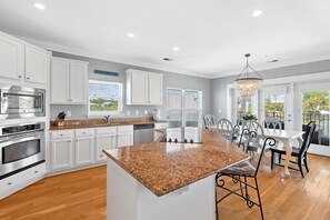 A modern kitchen with white cabinetry, granite countertops, and stainless steel appliances. - Sea Sanctuary | Pool | 3 Balconies | Near Beach (Seacrest Beach)
