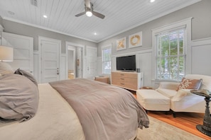 A bedroom with a large bed, a television, a dresser, and a window with blinds. - 🌊Second Wind | Screened Porch | 4 Bikes 🚲 | Sleeps 8 (Santa Rosa Beach)