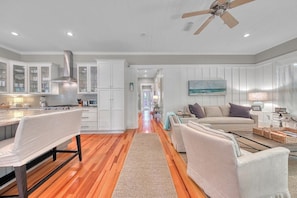 A spacious kitchen with white cabinetry, a wooden floor, and a ceiling fan. - 🌊Second Wind | Screened Porch | 4 Bikes 🚲 | Sleeps 8 (Santa Rosa Beach)