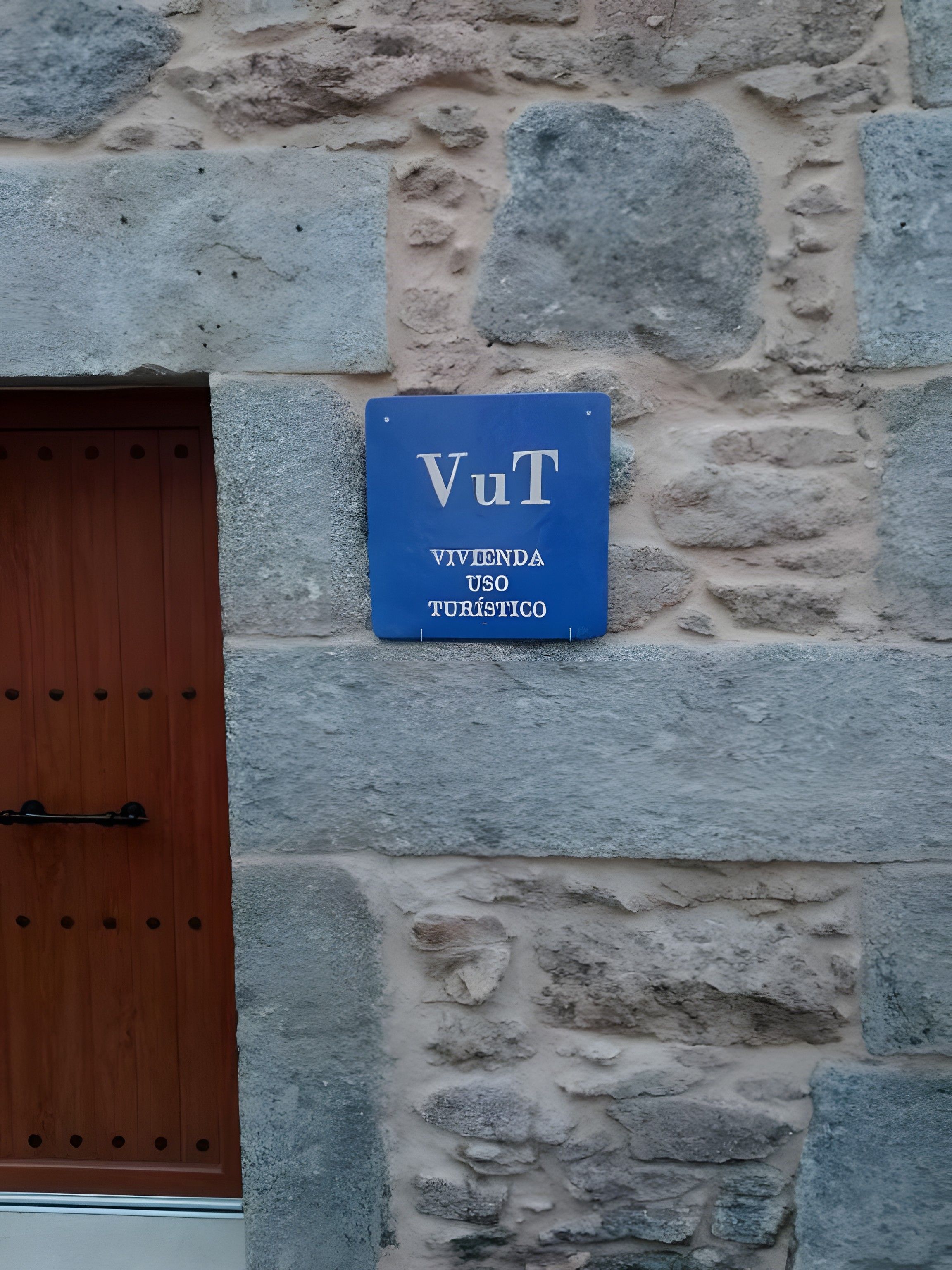 A blue sign with white text on a stone wall, indicating a tourist use area.