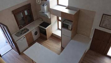 Una cocina compacta con lavabo, lavadora, microondas y un refrigerador pequeño.