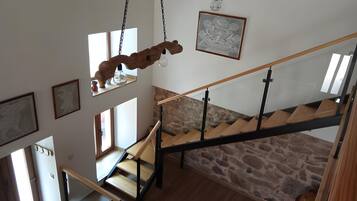 A staircase with a wooden handrail and stone wall.