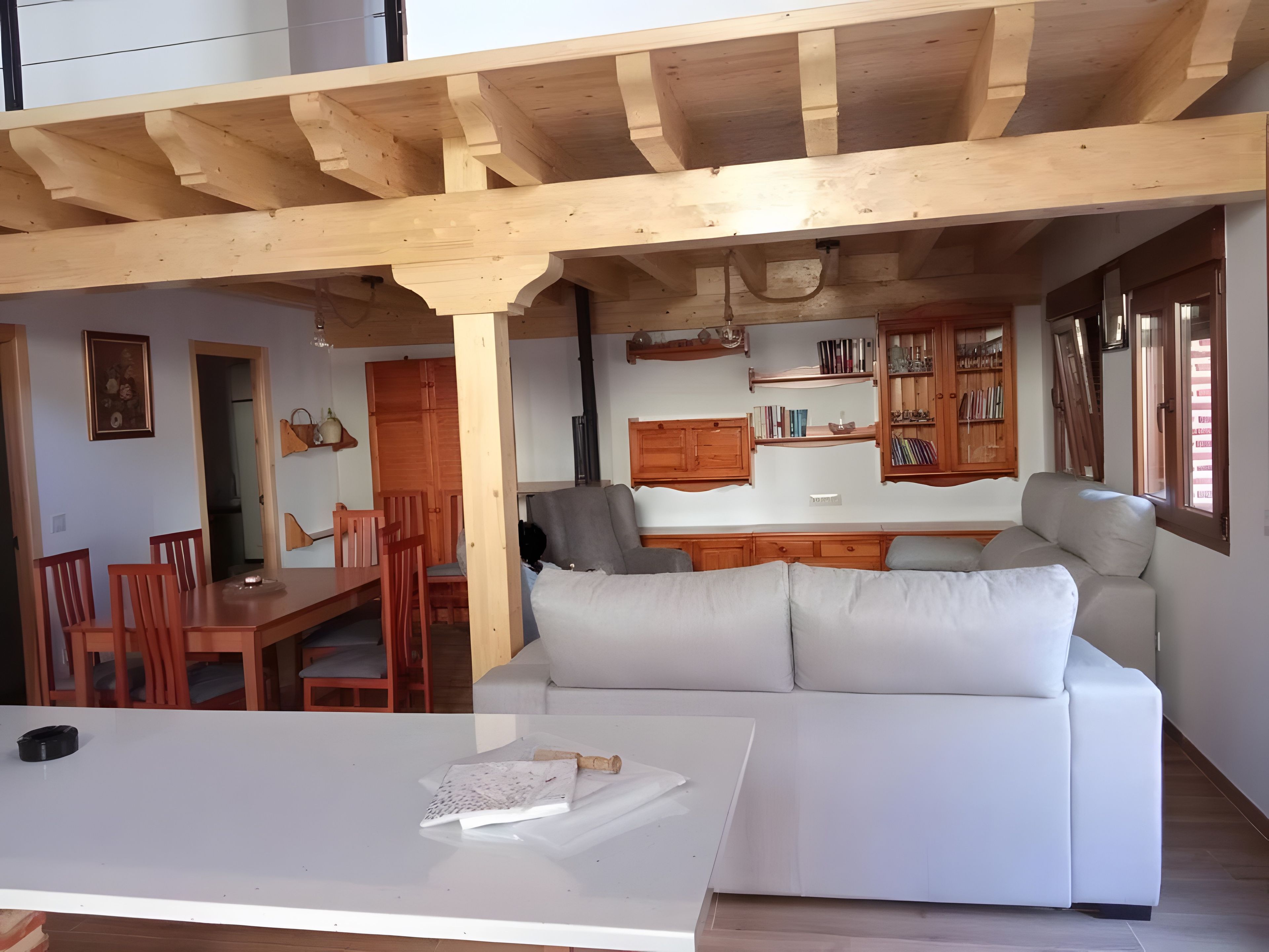 A modern interior with a dining area, sofa, and kitchen.