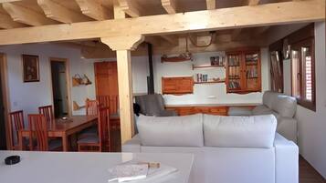 A modern interior with a dining area, sofa, and kitchen.