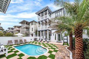 A residential property with a swimming pool, outdoor seating, and a well-maintained garden. - Stepping Stone Main & Carriage | Pool | Sleeps 14 (Inlet Beach)