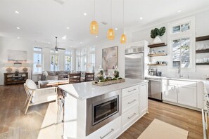A spacious kitchen with a large island, stainless steel appliances, and pendant lighting. - Stepping Stone Main House | Pool | Steps from Rosemary Beach (Inlet Beach)