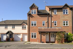 A two-story brick house with a tiled roof, a garage, and a front porch. - Townhouse on the River, Decking & Private Parking (Bristol City)