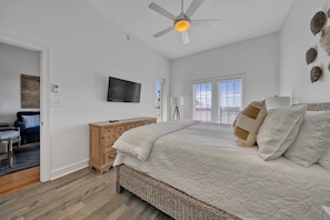 A bedroom with a bed, a dresser, a television, and a ceiling fan. - Village of South Walton F307-Vitamin Sea | Condo | Pool & Hot Tub | Sleeps 8 (Alys Beach)