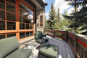 A deck with outdoor furniture, a railing, and a view of trees. - Spruce Slopeside Ski-in Access (Avon)