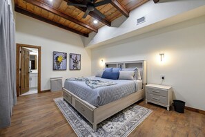 A bedroom with a bed, bedside tables, a rug, and artwork on the walls. - Amenity-Packed! Pool, Pickleball, Sauna, Hot Tub (Broken Bow)
