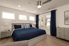 A bedroom with a bed, nightstands, a dresser, a ceiling fan, and windows with curtains. - Irish Trail Retreat | 1 Mile from ND (South Bend)