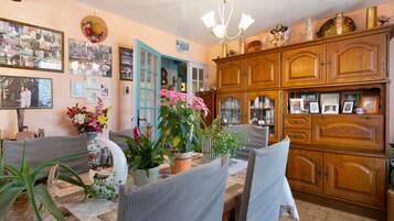 Ein gemütliches Wohnzimmer mit Essbereich, Holzschränken und verschiedenen gerahmten Fotos an den Wänden.