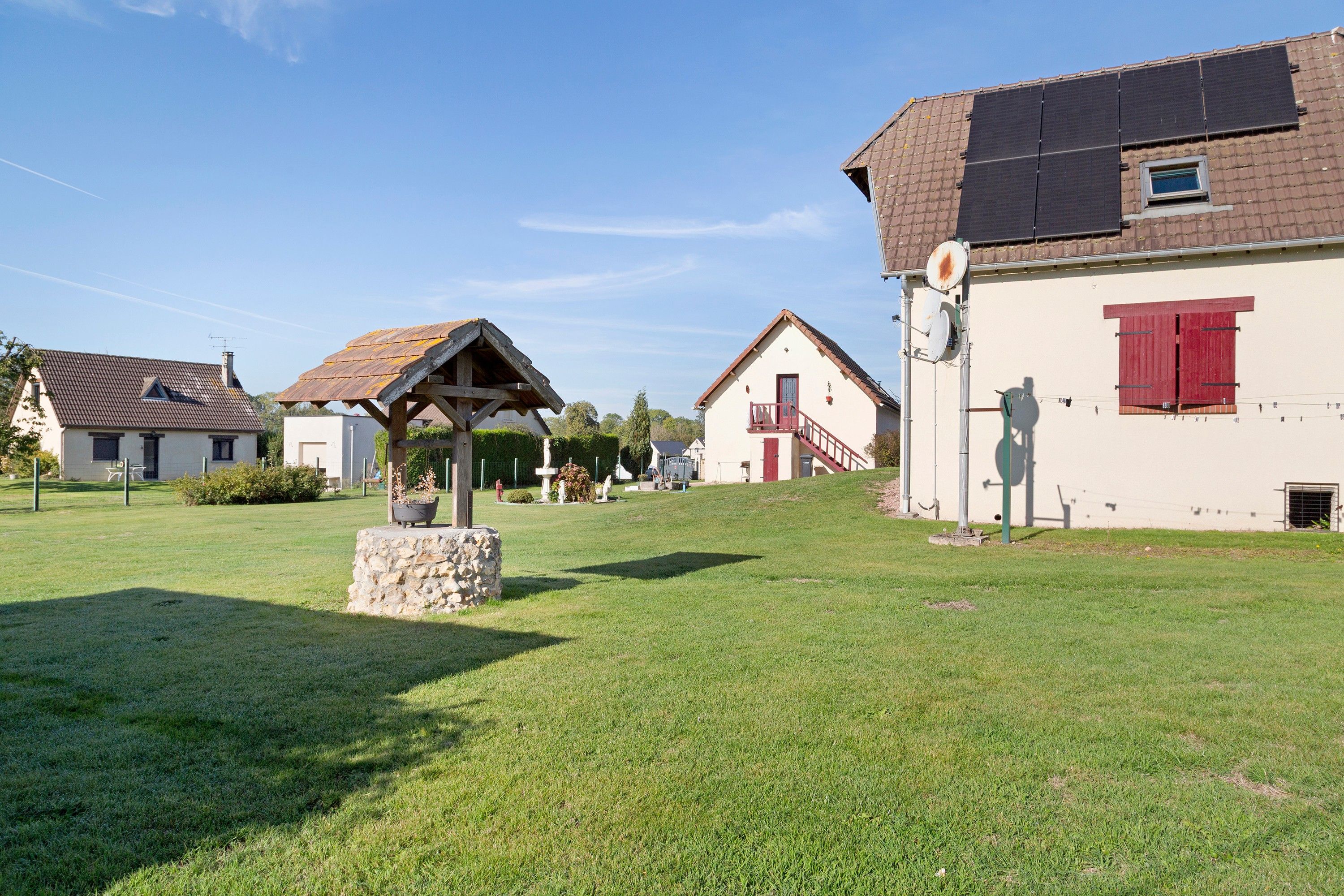 Una zona residencial con casas, un monumento de piedra y cielo despejado.