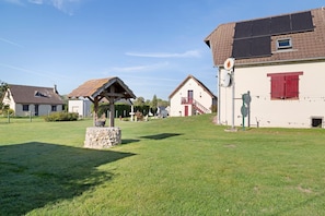 A residential area with houses, a stone monument, and a clear sky.